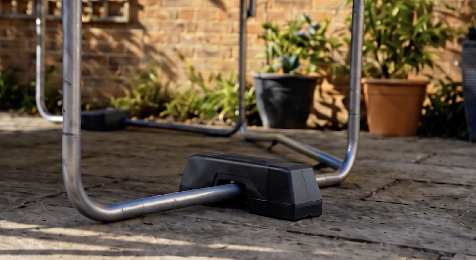 Trampoline Weight installed over a ground tube near a trampoline leg